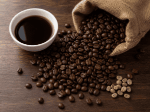 Roasted coffee beans spilling from a burlap sack onto a dark walnut table beside a white ceramic cupping bowl